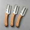 S513ddaea612045edb2584e035a73b038H.webp Stainless steel peeler with wooden handle for peeling and slicing fruits and vegetables | Durable and smooth operation