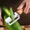 Sfd796a7f2ff3437492ac292c5b2f6193Z.webp Stainless steel peeler with wooden handle for peeling and slicing fruits and vegetables | Durable and smooth operation